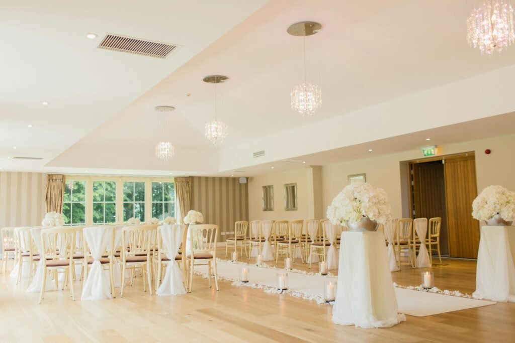 Brightly lit indoor wedding venue with elegant seating and floral decor, perfect for luxurious ceremonies.