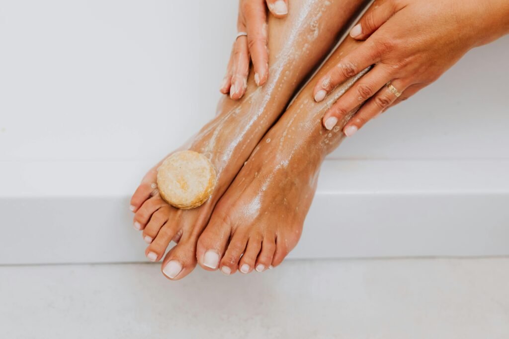 Close-up of a woman's feet being washed with organic soap for skincare and relaxation.