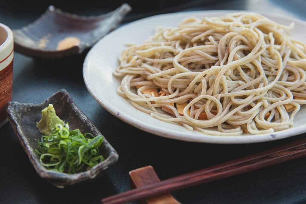Delicious plate of traditional Japanese soba noodles served with wasabi and scallions, ideal for a healthy meal.