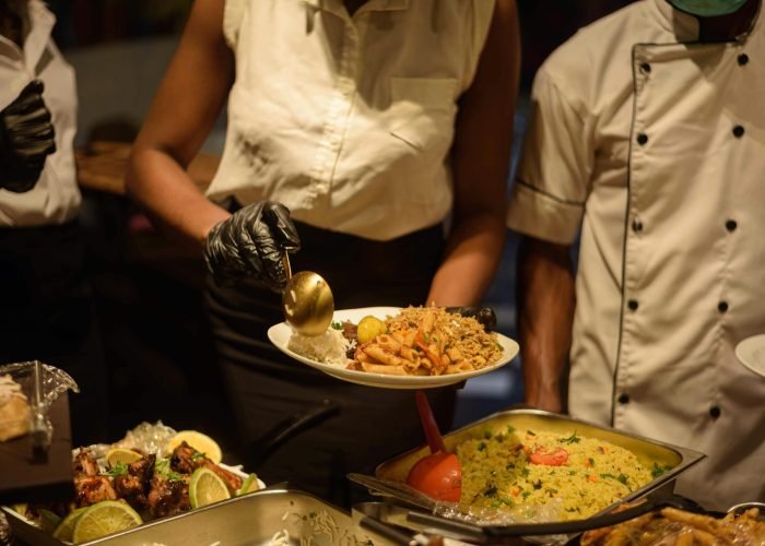 Catering service in Enugu, Nigeria with delicious buffet offerings served by staff.