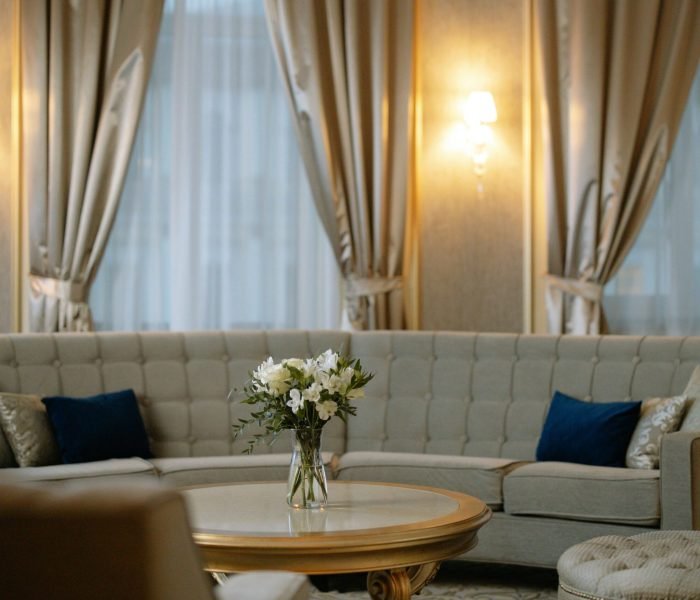 Luxurious lounge area featuring a plush sofa, chic curtains, and soft lighting.