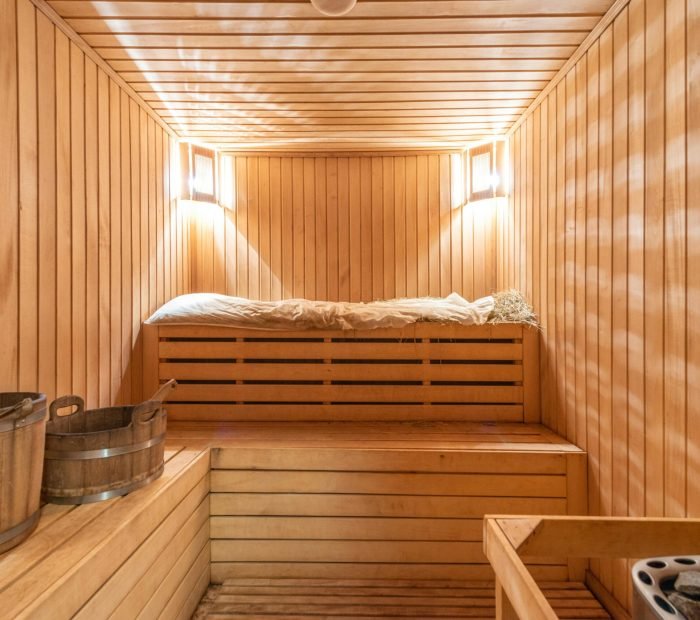 Warm and inviting wooden sauna with ambient lighting, perfect for relaxation.