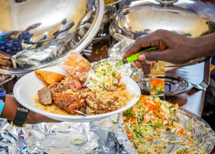 A vibrant plate of Nigerian cuisine being served at a buffet, showcasing local delicacies.